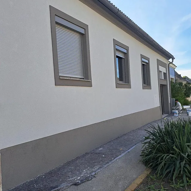 Bild eines Hauses mit weißen Wänden und Fenstern, fotografiert von Malerie Imeri.