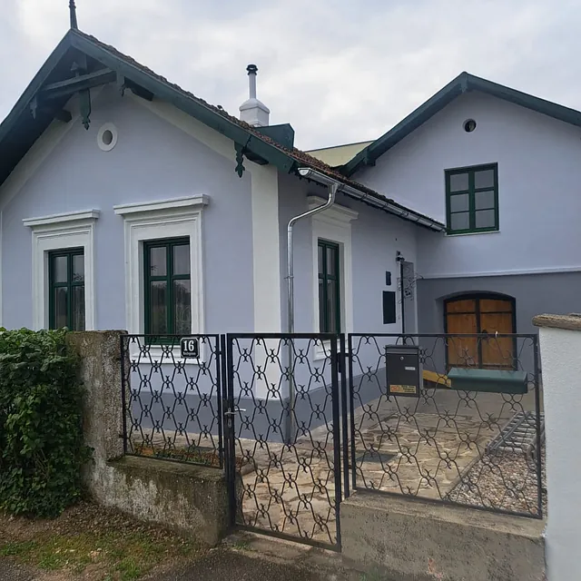 Ein Haus mit einem Tor und einem Zaun umgibt das Grundstück.
