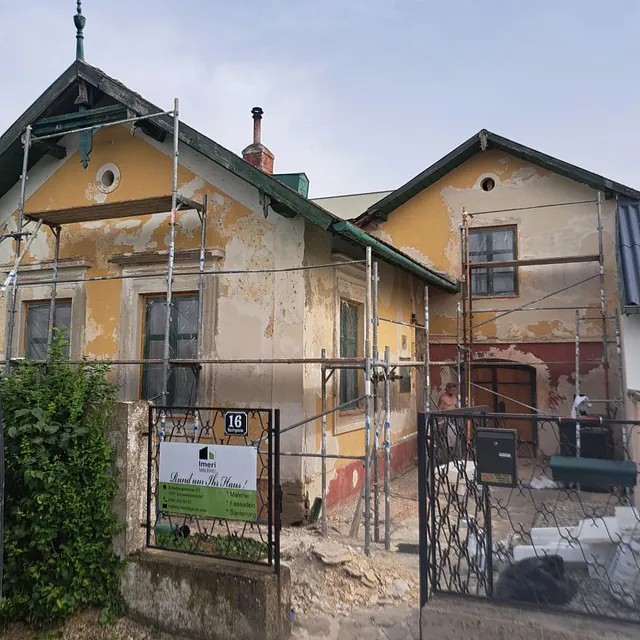 Ein renoviertes Haus mit Baugeräten und Materialien im Vordergrund.